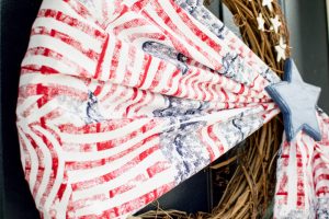 Welcome friends & family to your home all summer long with this simple Patriotic wreath! Made with stars & stripes fabric, wooden stars, & a grapevine base.
