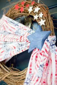 Welcome friends & family to your home all summer long with this simple Patriotic wreath! Made with stars & stripes fabric, wooden stars, & a grapevine base.