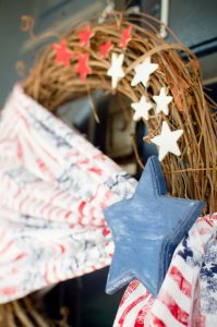 Welcome friends & family to your home all summer long with this simple Patriotic wreath! Made with stars & stripes fabric, wooden stars, & a grapevine base.