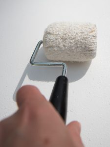 Use a paint roller to cover your wood sign with acrylic paint
