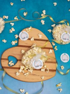 gender neutral baby shower gift tags tied to bags of fresh popcorn